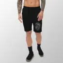 Man wearing black fleece shorts with line drawing of a lion head on the left leg