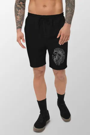 Man wearing black fleece shorts with line drawing of a lion head on the left leg